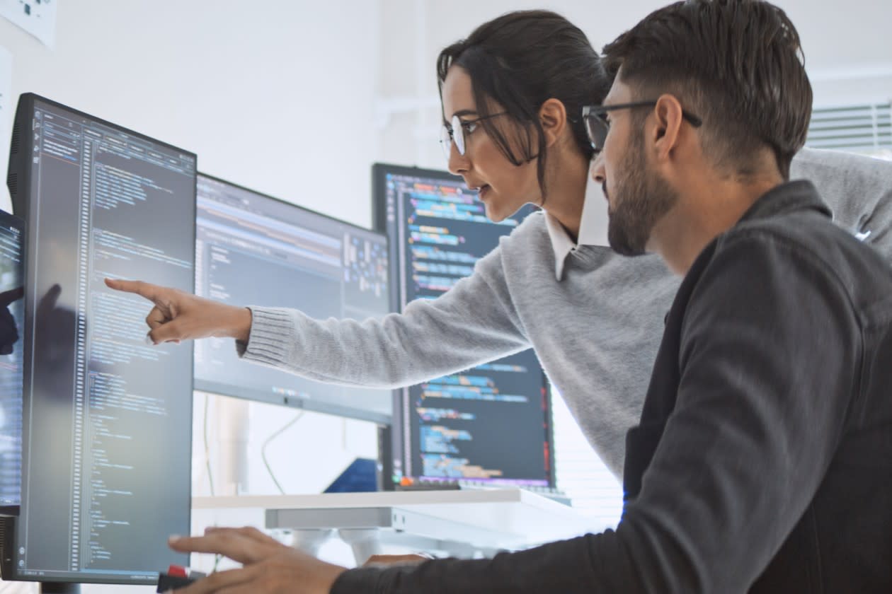 Cyber security professionals discussing an issue on their office monitors.jpg