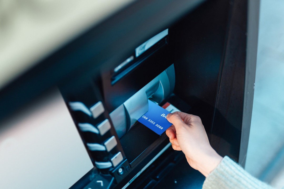 Bank customer making a withdrawal from an ATM machine.jpg