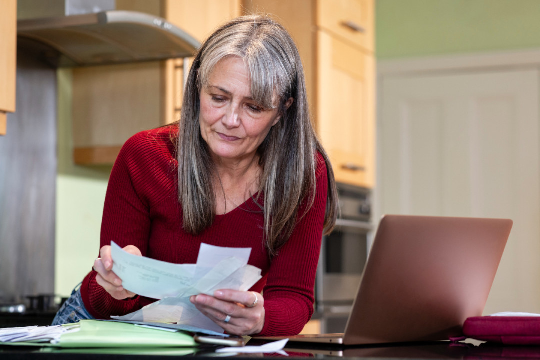 A concerned woman doing her finances- GettyImages