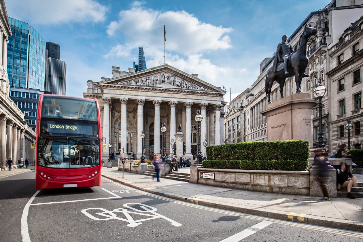 Bus waiting in front of the London Stock Exchange building on a sunny day.jpg