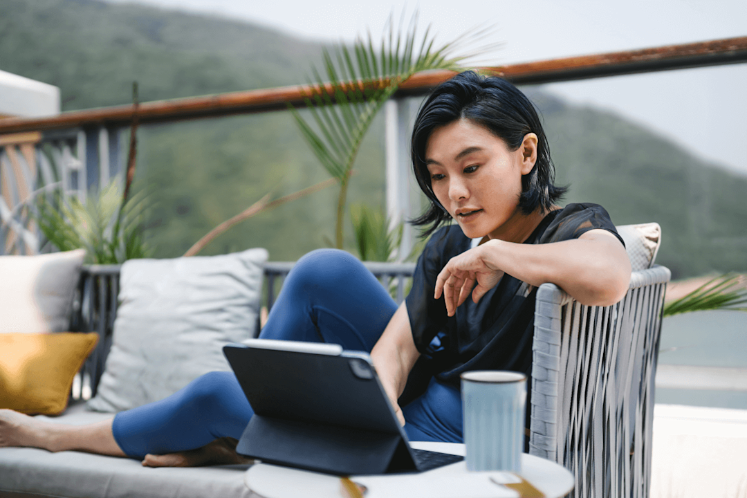 Young female using computer for leisure or business at home.