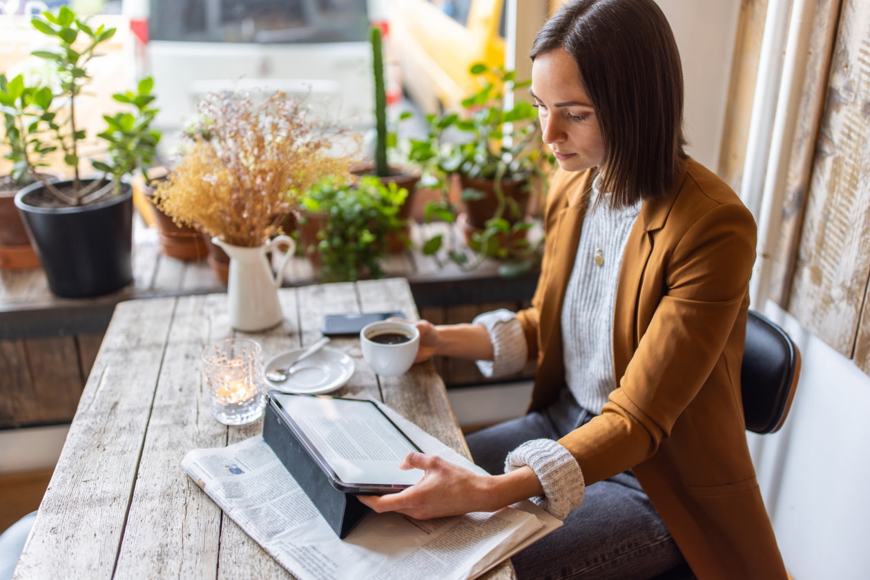 Woman sitting reading the news on her tablet.jpg