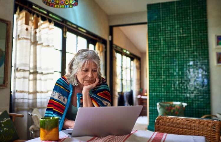 Pensioner checking laptop in her kitchen.jpg