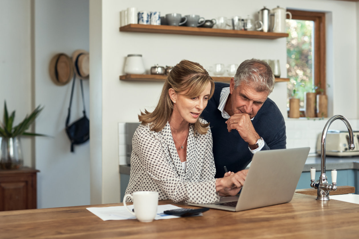 A senior couple planning their finance and paying bills while using a laptop at home.jpg