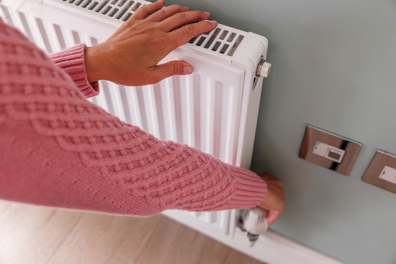 Woman turning up the heat on her radiator