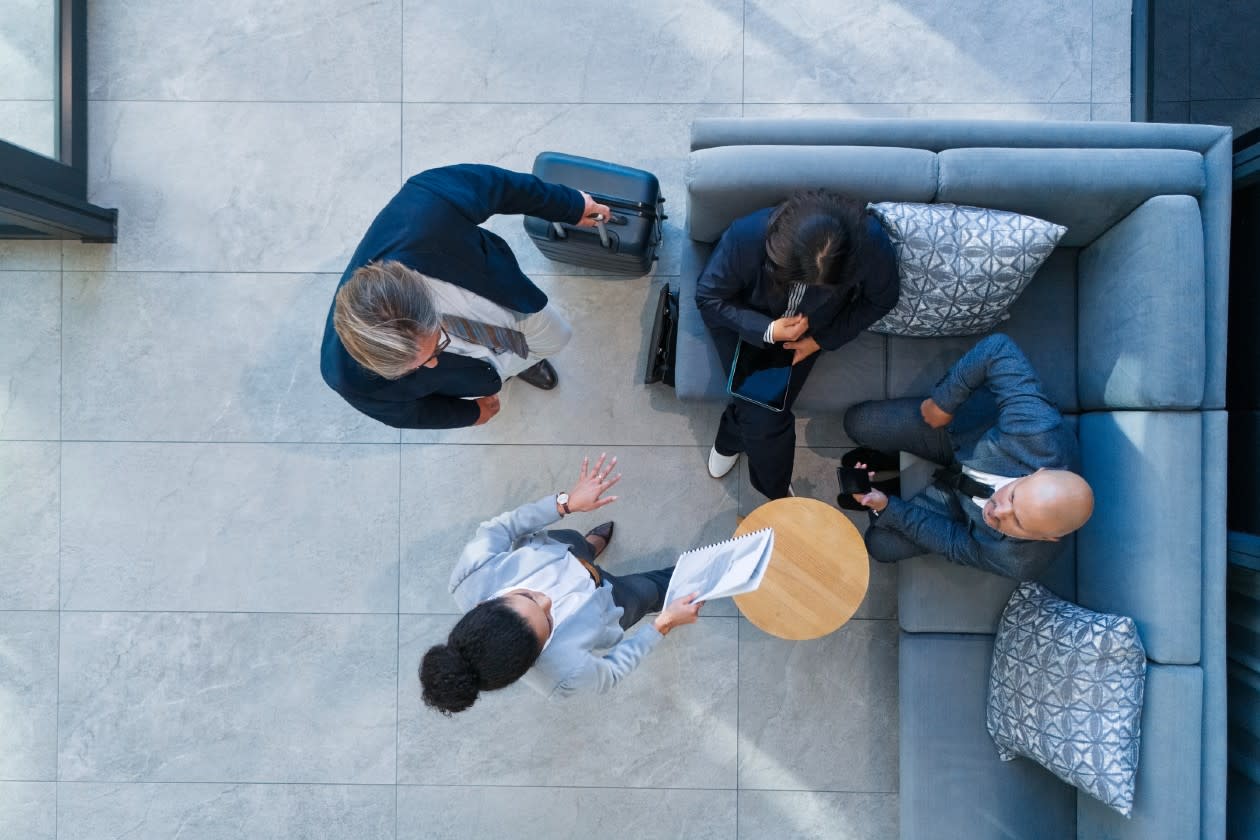 Employees chatting in an office booth from above.jpg