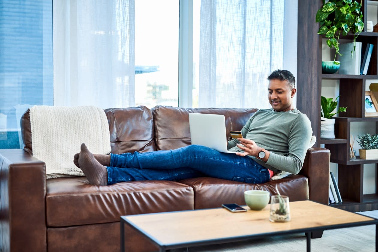 Man relaxing on the sofa while doing online shopping.jpg