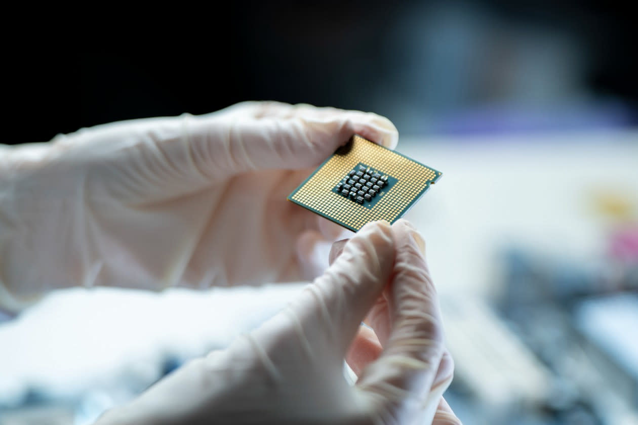 Technician holds up a computer chip for inspection.jpg