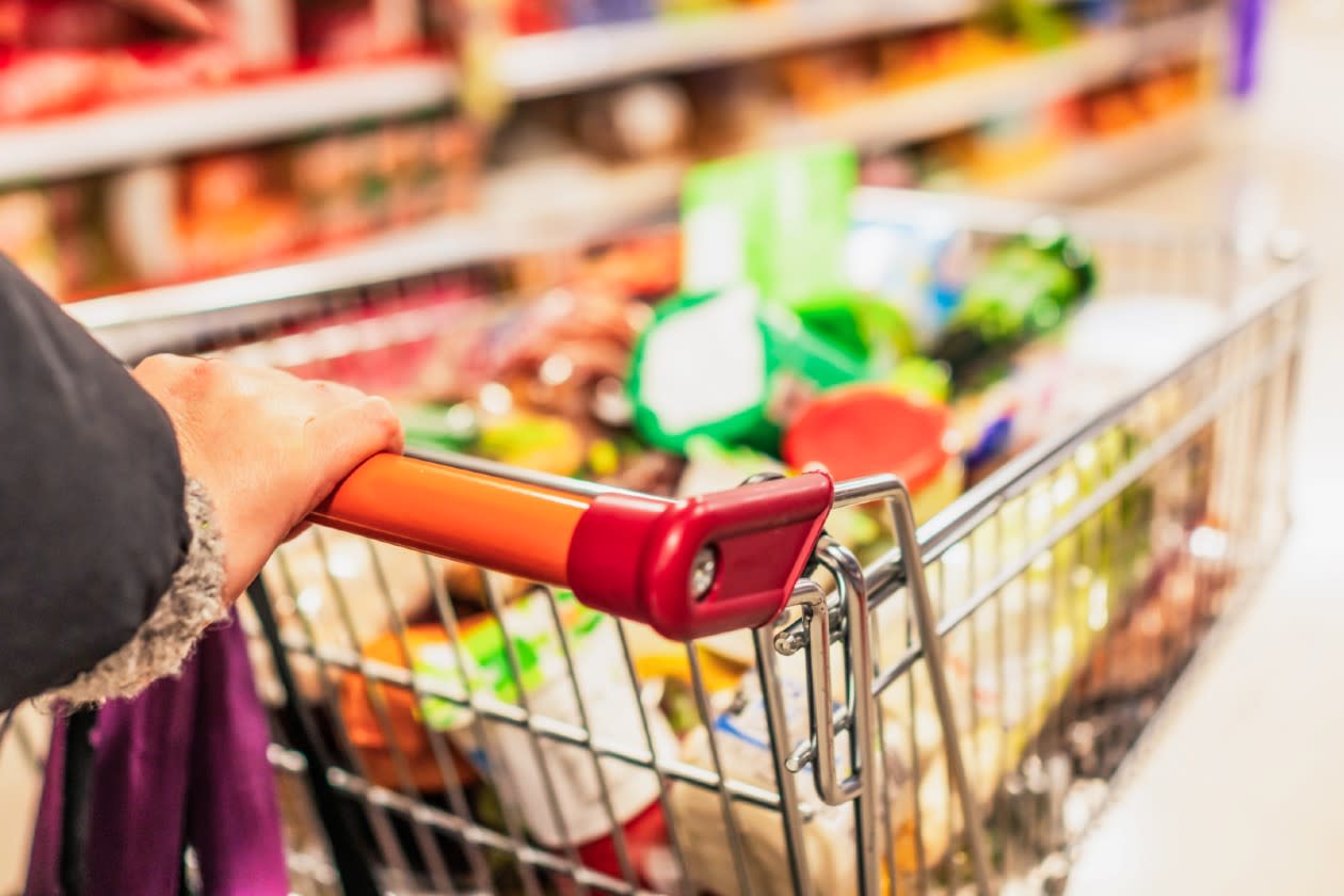 Sainsbury - woman pushing a full shopping trolly around a store.jpg